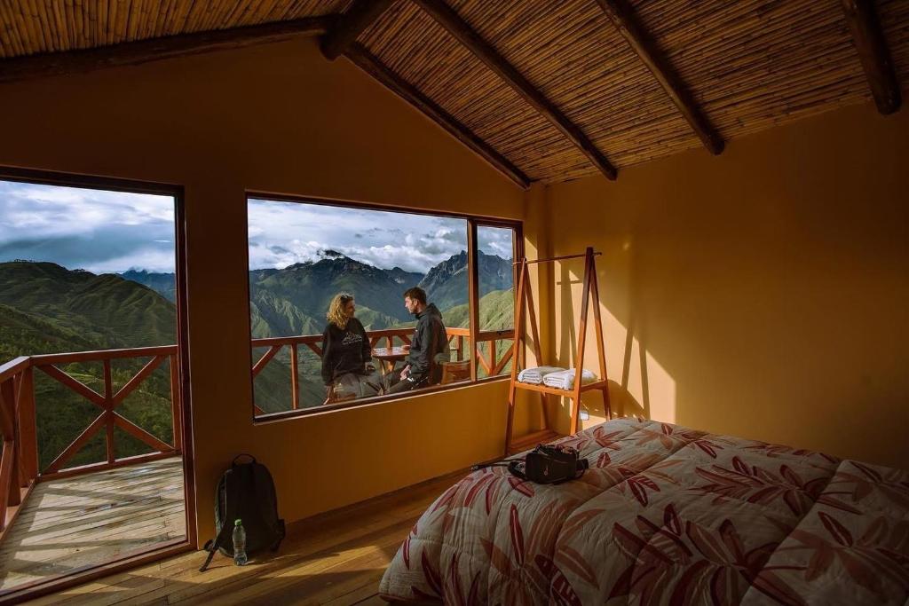 a couple standing in a room with a window at Mountain View Lodge & Experience in Cusco