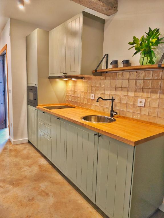 a kitchen with white cabinets and a sink at AIXPE apartamentos boutique in Osma