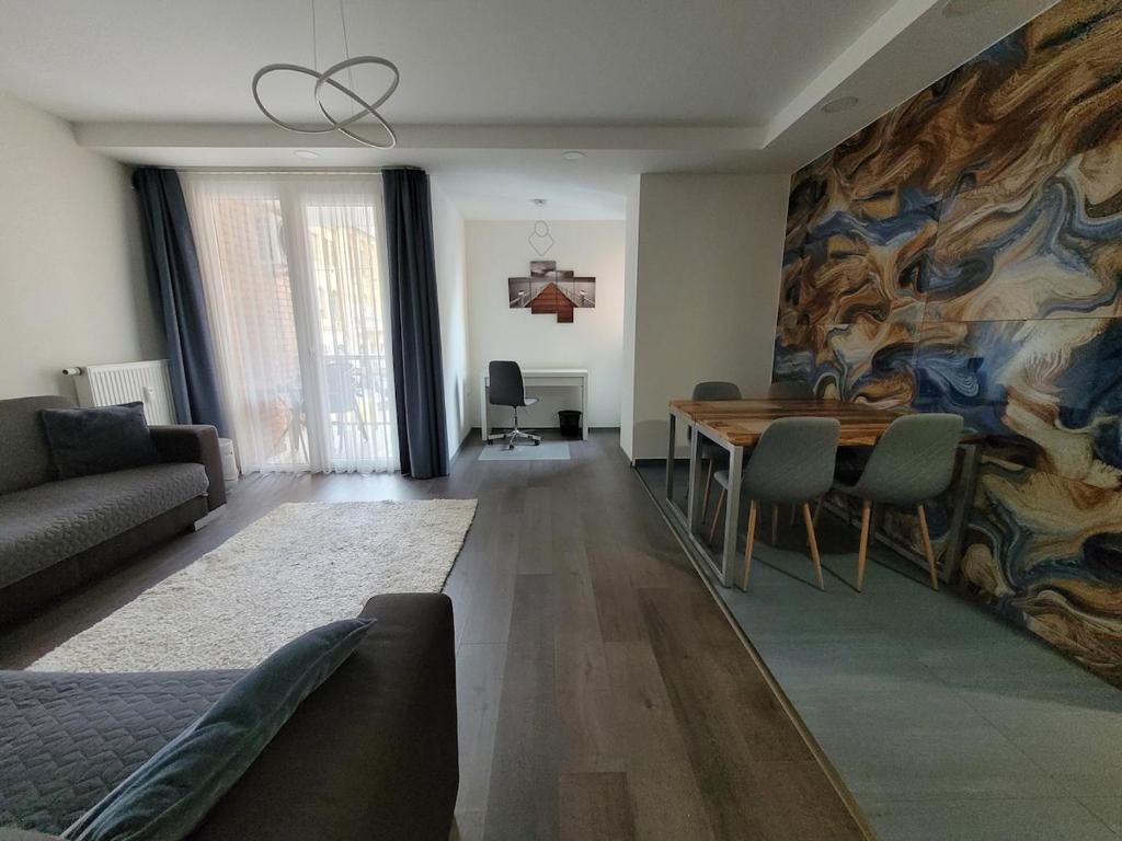 a living room with a table and a painting on the wall at Magic Downtown Szeged in Szeged