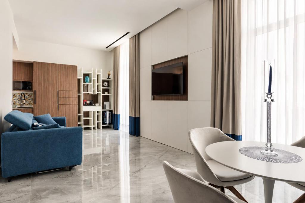 a living room with a table and a blue couch at ViaRomaHome - Salerno in Salerno