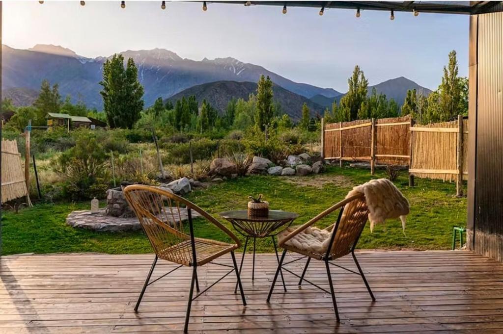 two chairs and a table on a deck with a view at El Castaño Apart in Potrerillos