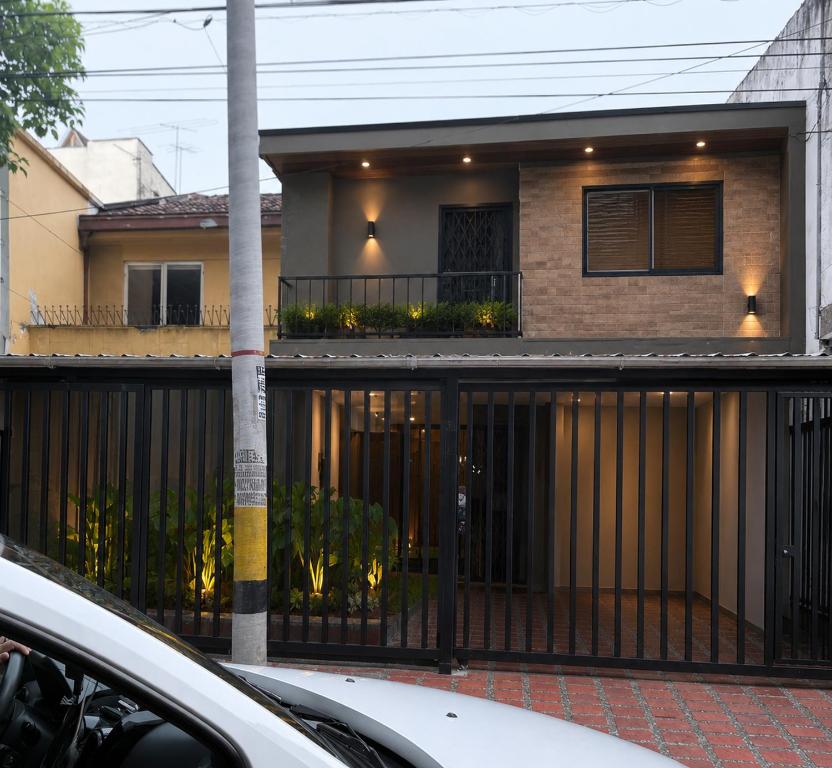 a house with a black fence in front of it at Casa hotel la 33 in Medellín