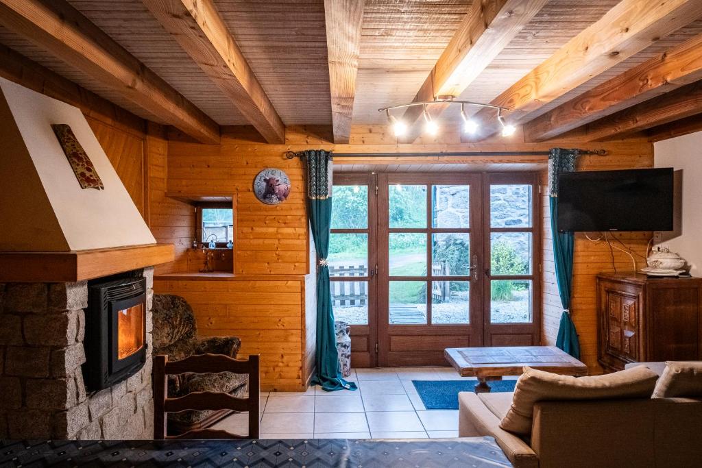 a living room with a fireplace and a tv at la bergerie in Mialanes