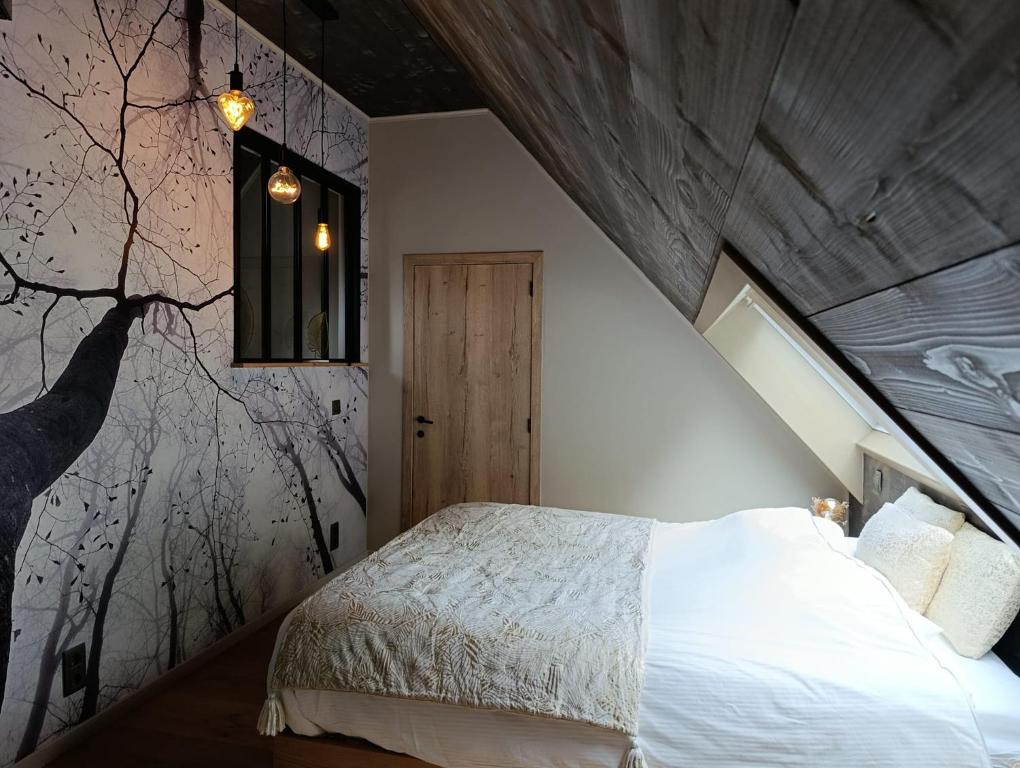 a bedroom with a bed and a tree mural at Terra Serena in Frasnes-lez-Anvaing