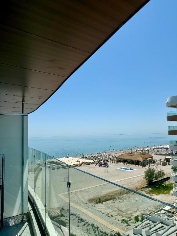 a view of the beach from the balcony of a building at Grand Panorama Residence in Mamaia