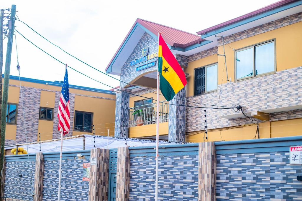 two flags flying in front of a building at EdJames Lodge in Ashaiman