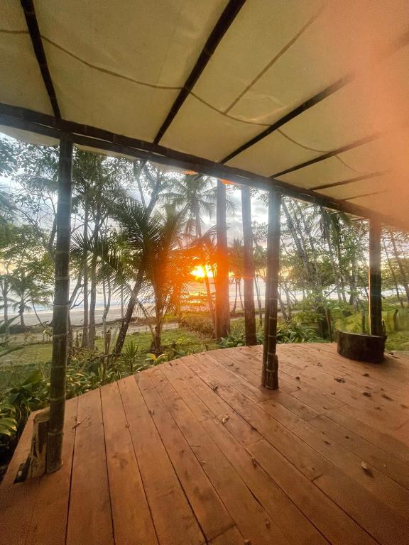 a view from the inside of a building with a wooden deck at Private Beachfront Beach Hut in Manzanillo