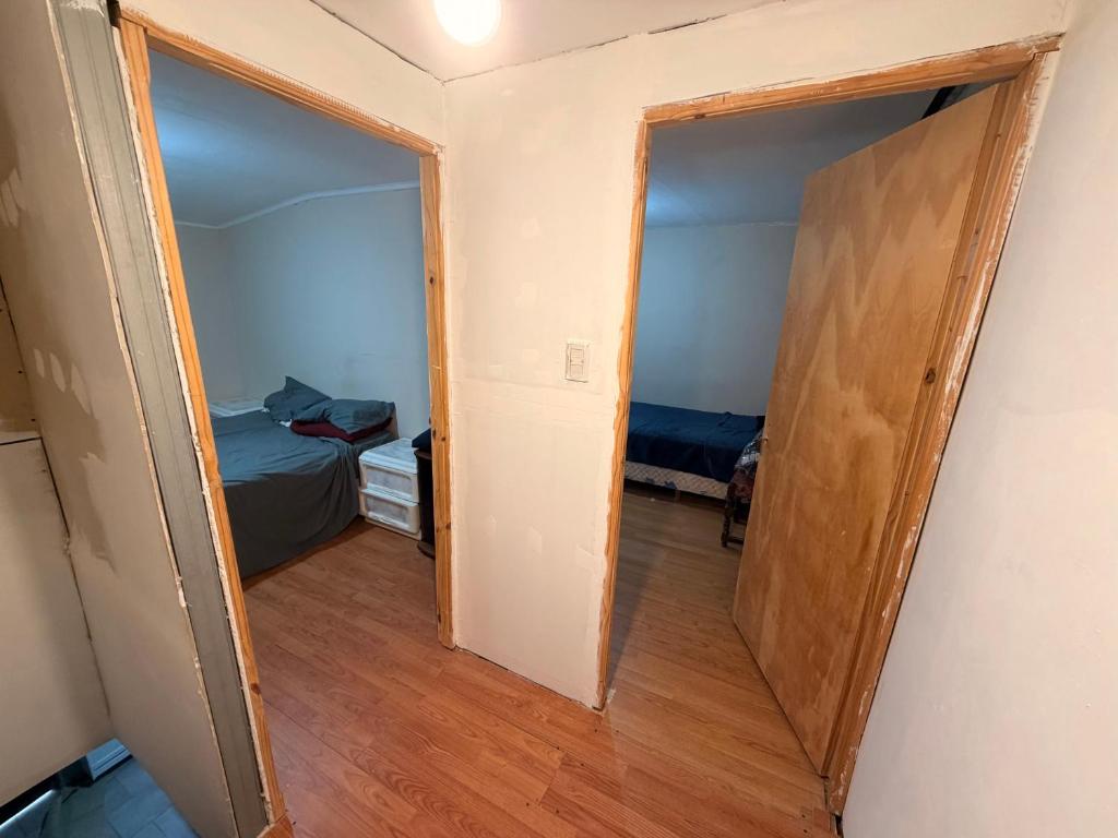 an open door to a room with a bedroom and a bed at Deptos Valen in Trevelín