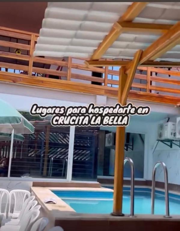 a swimming pool with a sign on the side of a building at Casa playera in Crucita