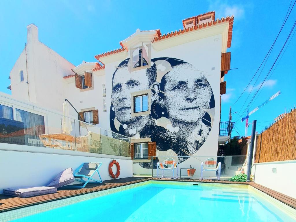 a mural on the side of a building with a swimming pool at Casa do Joaquim da Praia in Nazaré
