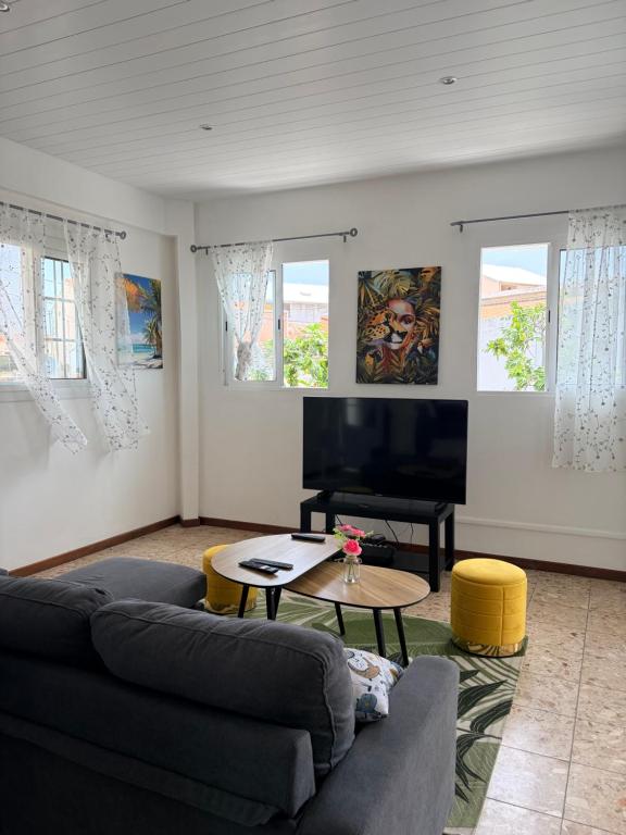 a living room with a couch and a table at Logement au vauclin in Le Vauclin