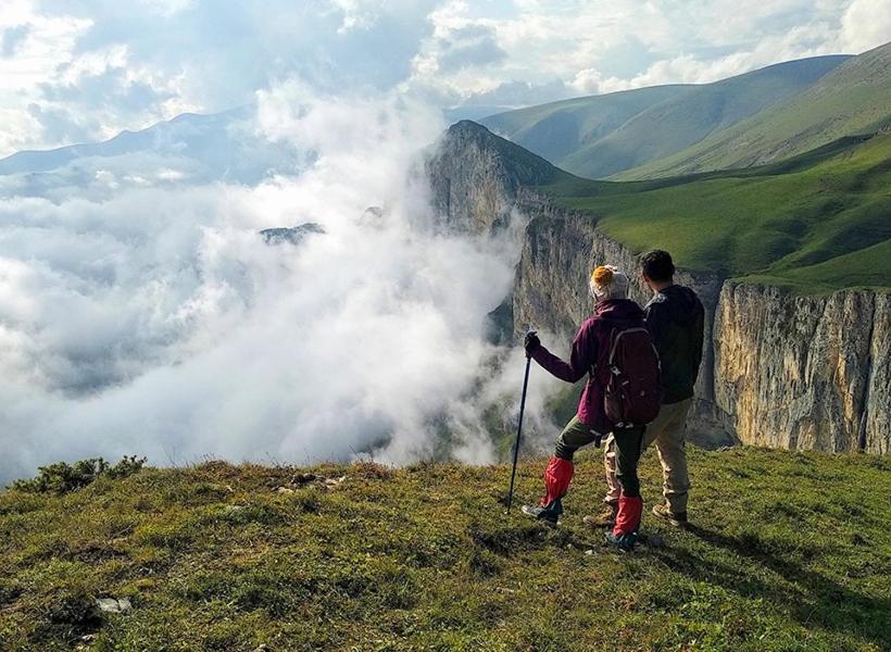 two people standing on top of a mountain with clouds at Remember Me B&B in Dilijan