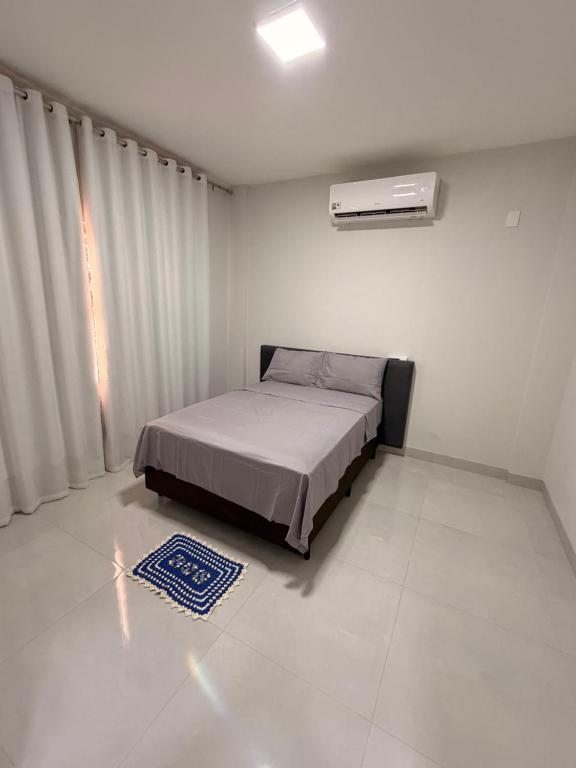 a white room with a bed and a window at Apartamento Completo e confortável em Sinop Mt in Sinop