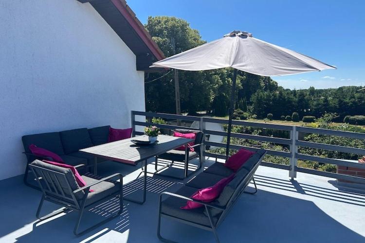 a patio with a table and chairs and an umbrella at Apartment in Dabrowa near the Sea in Gostyniec