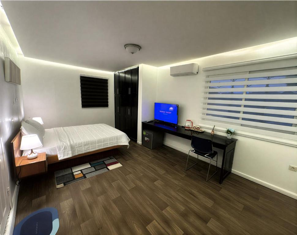 a bedroom with a bed and a desk with a computer at Melroseplace Complex in Bonabéri