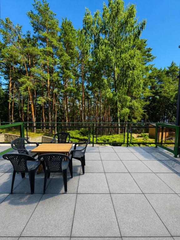 a picnic table and chairs on a patio with trees at STUDIO LEŚNE z DUŻYM TARASEM nad Zalewem in Serock