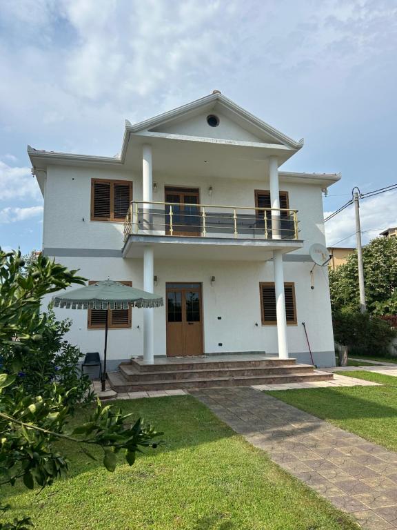 a white house with a porch and a balcony at VillaSolmare Velipoje in Velipojë