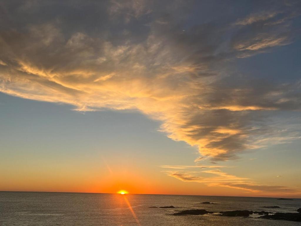 a sunset over the ocean with a cloudy sky at Heavenly Properties SLM in Scituate