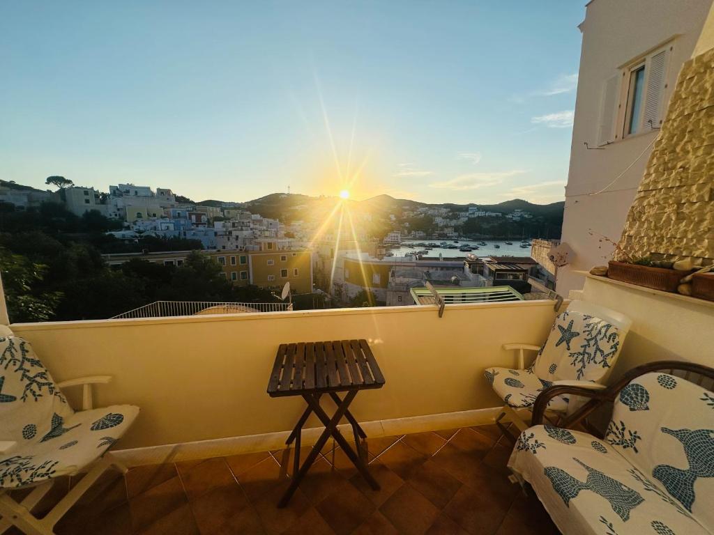 a balcony with chairs and a table and the sun at PELAGOS - Agenzia Immobilevante in Ponza