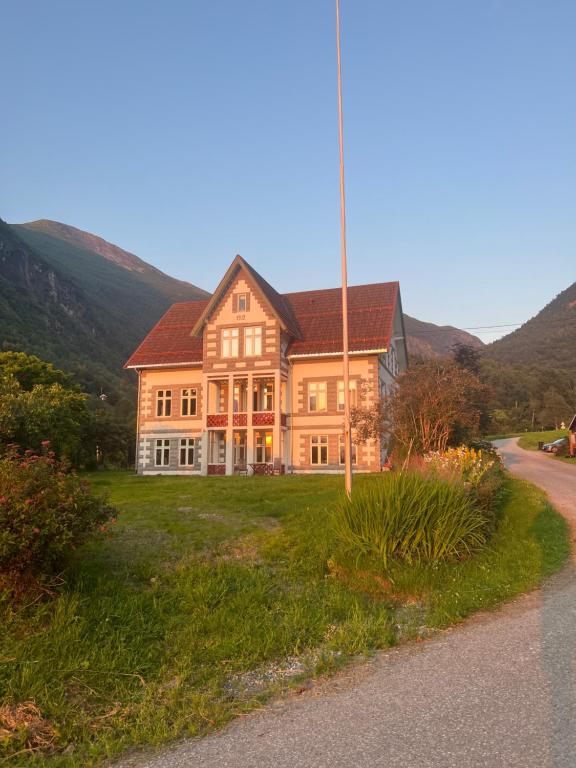 a large house on the side of a road at Dalhus Valley Apartment in Norddal