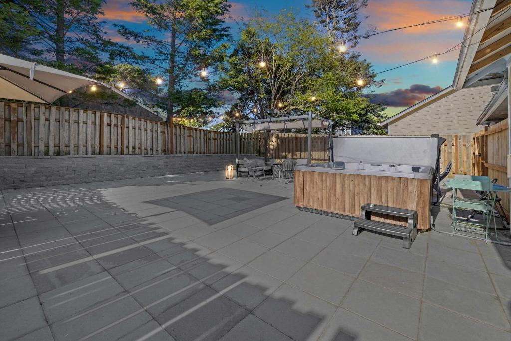 a patio with a bench and a fence at Cozy Seaside Bungalow, Brand New Hot Tub, Fast WiFi & W&D - Walk to the Beach in Seaside