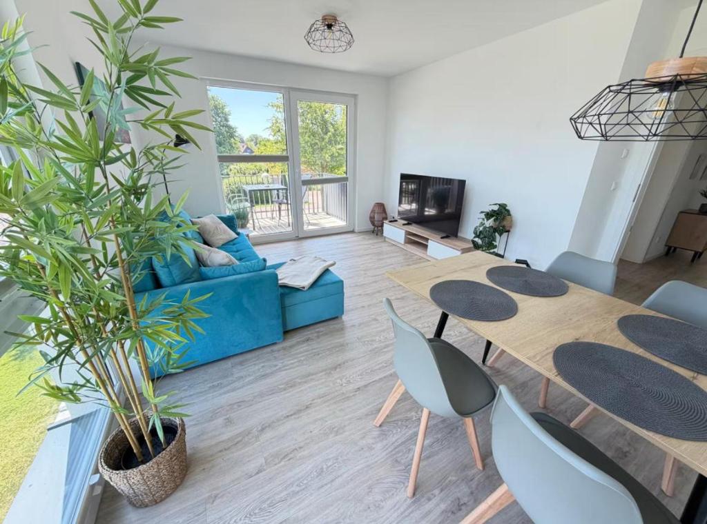 a living room with two tables and a blue couch at RegioStyle-Gemuetliche-Wohnung-im-Schaalseepark in Zarrentin