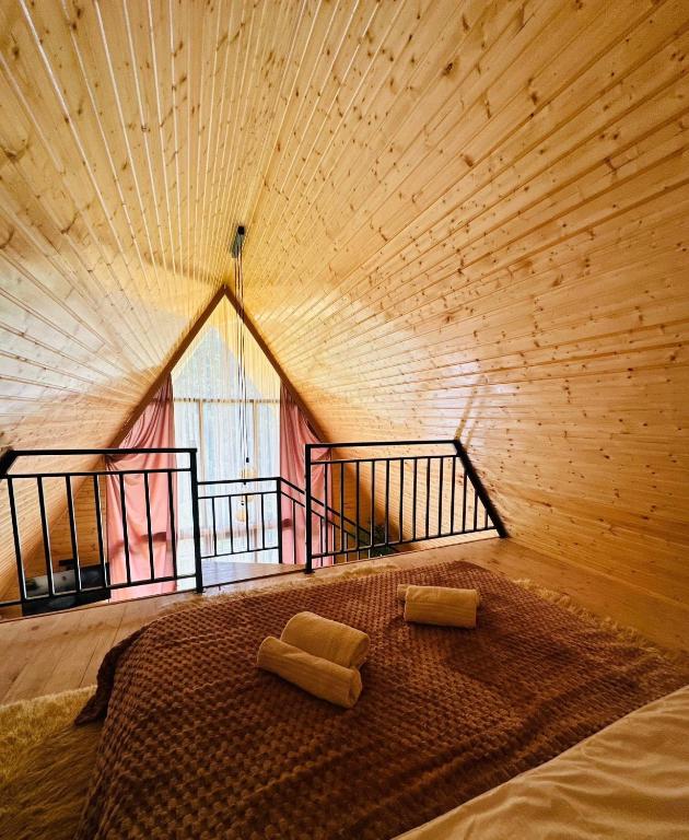 a large bed in a room with a wooden ceiling at River Sound Chalet in Tba