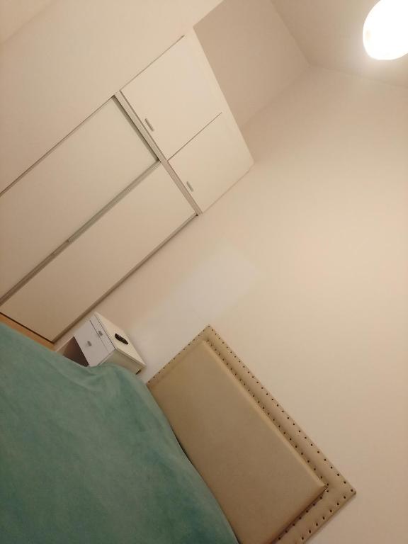 a bedroom with a bed and a white wall at Casa Estadio con cochera in Santiago del Estero