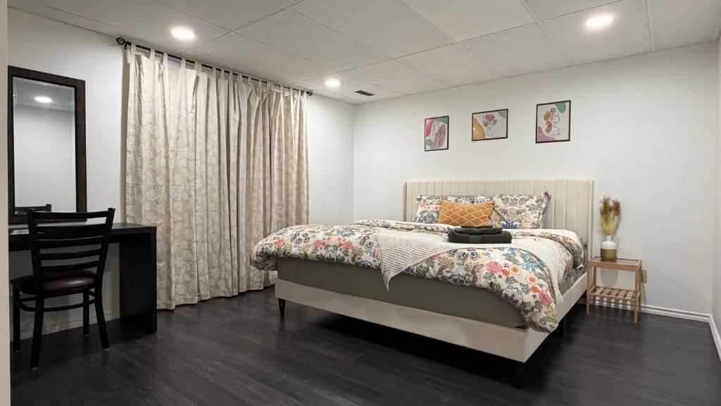 a bedroom with a bed and a table and a chair at Velora Stays in Kelowna