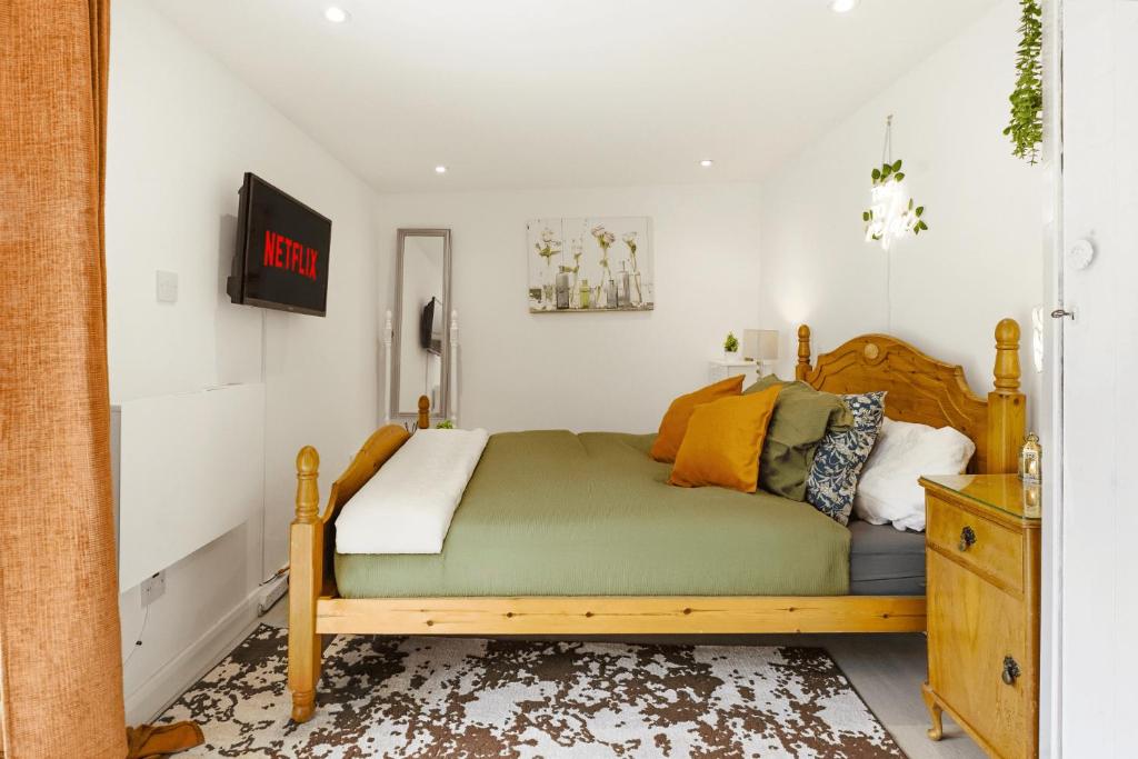 a bedroom with a wooden bed in a room at Garden Studio En-Suite in Egham