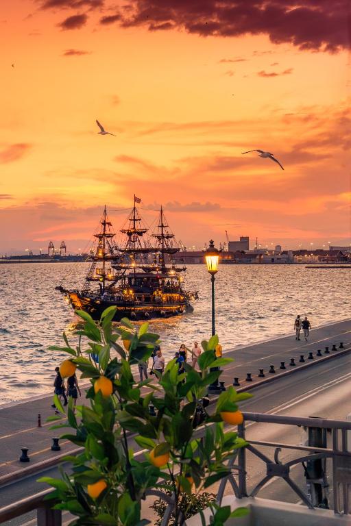 a ship in the water near a pier with a sunset at ICONIC LEGACY Suite seafront in Thessaloniki