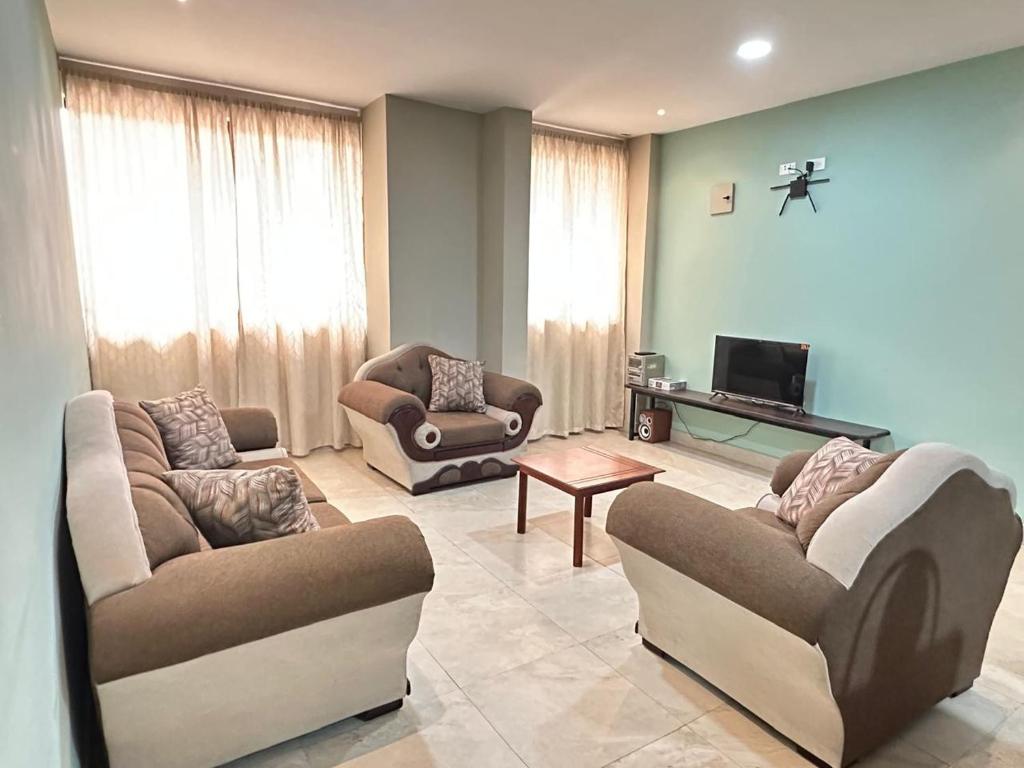 a living room with two couches and a tv at "Wampu" - Amplio apartamento cerca del Centro Histórico in Cuenca