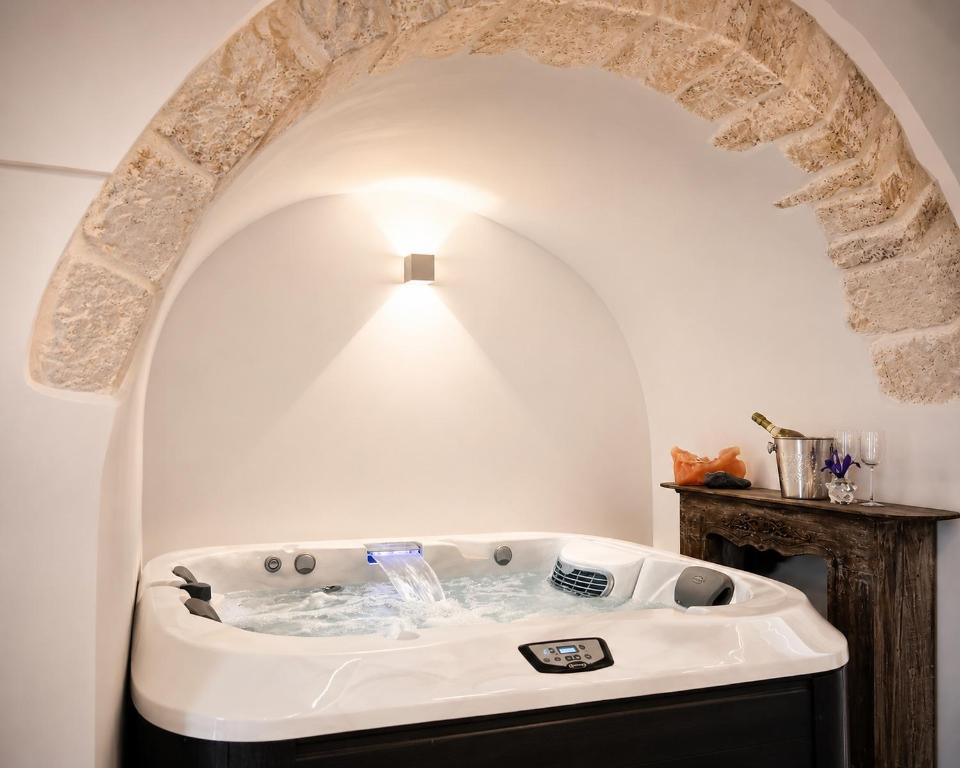 a bath tub in a room with an archway at Ostuni Luxury Room in Ostuni