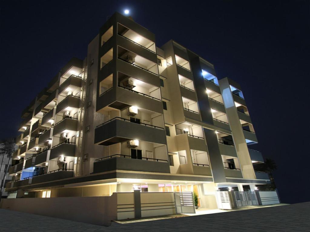 Devanhalli的住宿－Arra Grande Suites - Nearest Airport Hotels Bangalore，一座大型公寓楼,晚上有灯