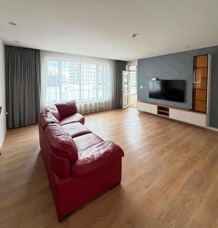 a living room with a couch and a flat screen tv at Mandala Garden Luxury Apartment in Ulaanbaatar