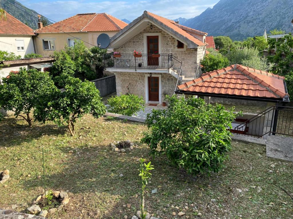 a house with a yard with trees and bushes at Charming Stone Cottage Kotor in Kotor