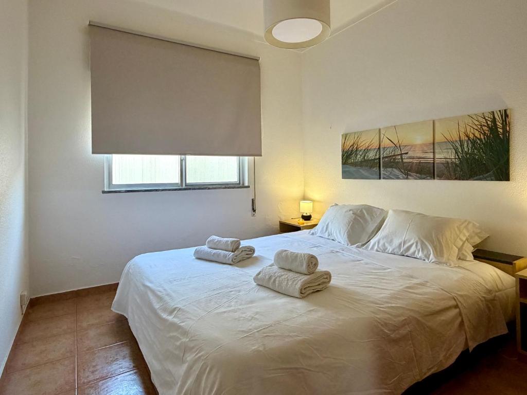a bedroom with a white bed with towels on it at Moradia Vila Real Sto Antonio in Vila Real de Santo António