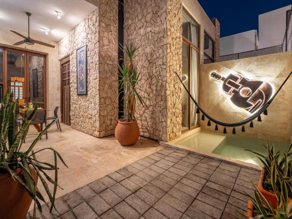 a room with potted plants and a sign on the wall at Casa Trova Santa Lucía with Parking by Cercana in Mérida