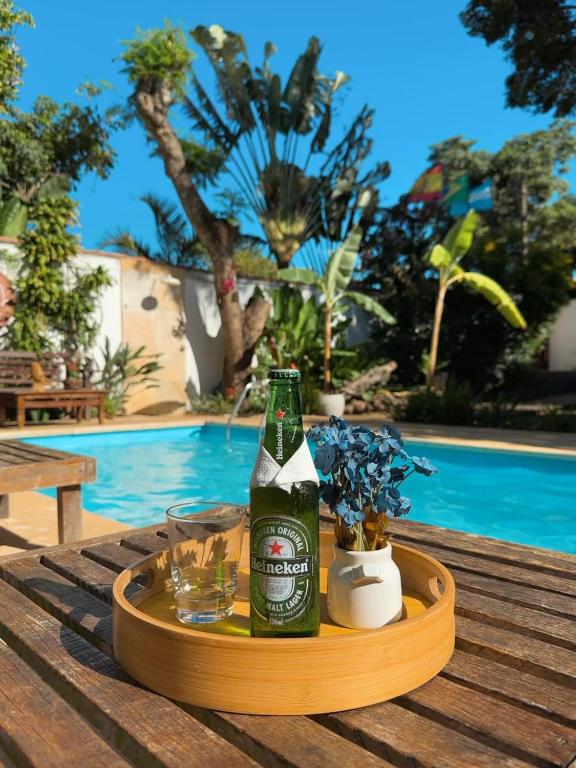a bottle of beer sitting on a table next to a pool at Casa Valldemossa in Búzios