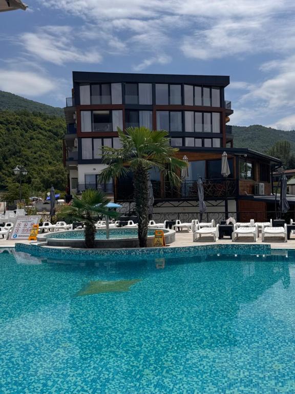 a hotel with a swimming pool in front of a building at Grand Lake View Apartment in Ohrid