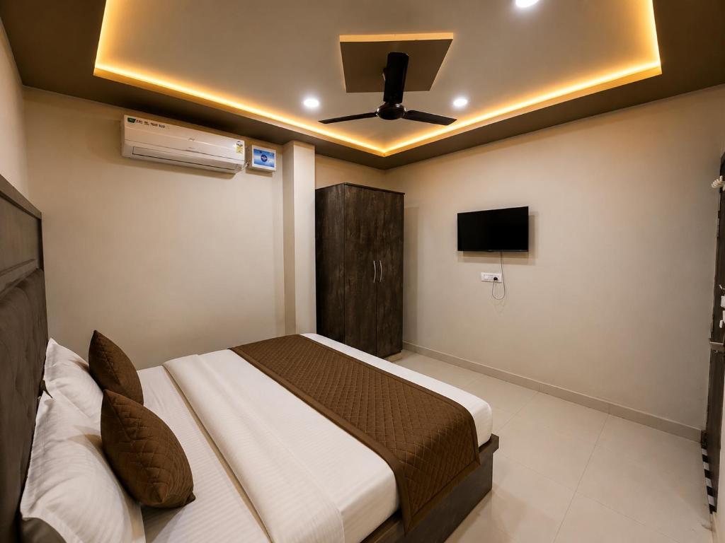 a bedroom with a bed and a ceiling fan at Hotel Jay Palace in Saraipāli