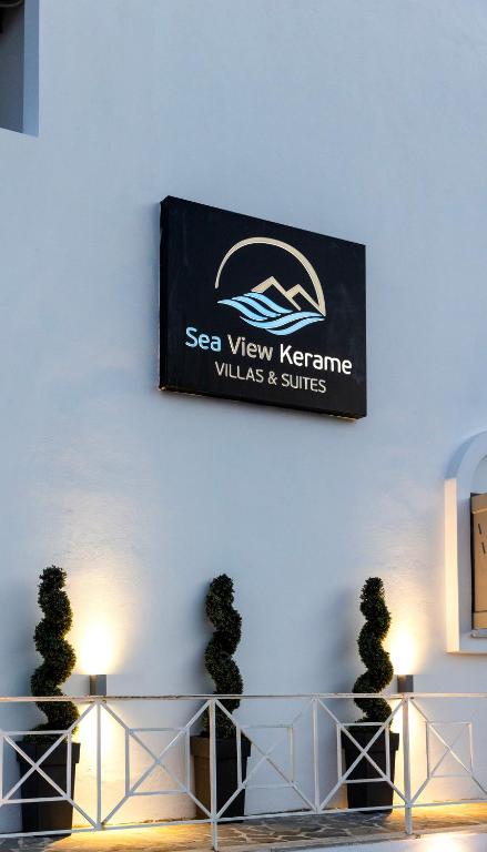 a sign on a wall with two potted trees in front at Sea View Kerame in Evdilos