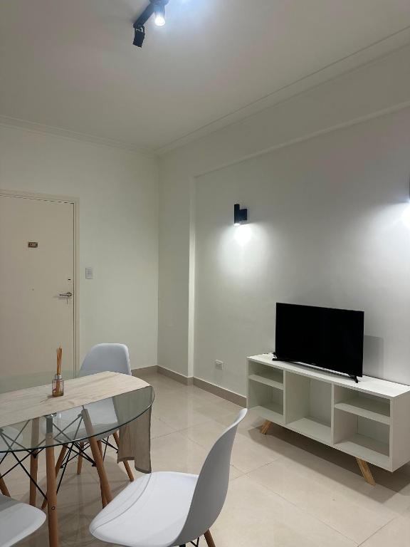 a living room with a tv and a table and chairs at Colón 2 in Mar del Plata