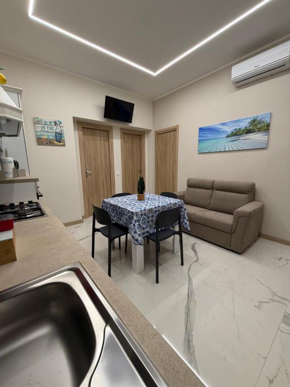 a kitchen and living room with a table and a couch at Catalano Suite Giada - Vista Mare in Palermo