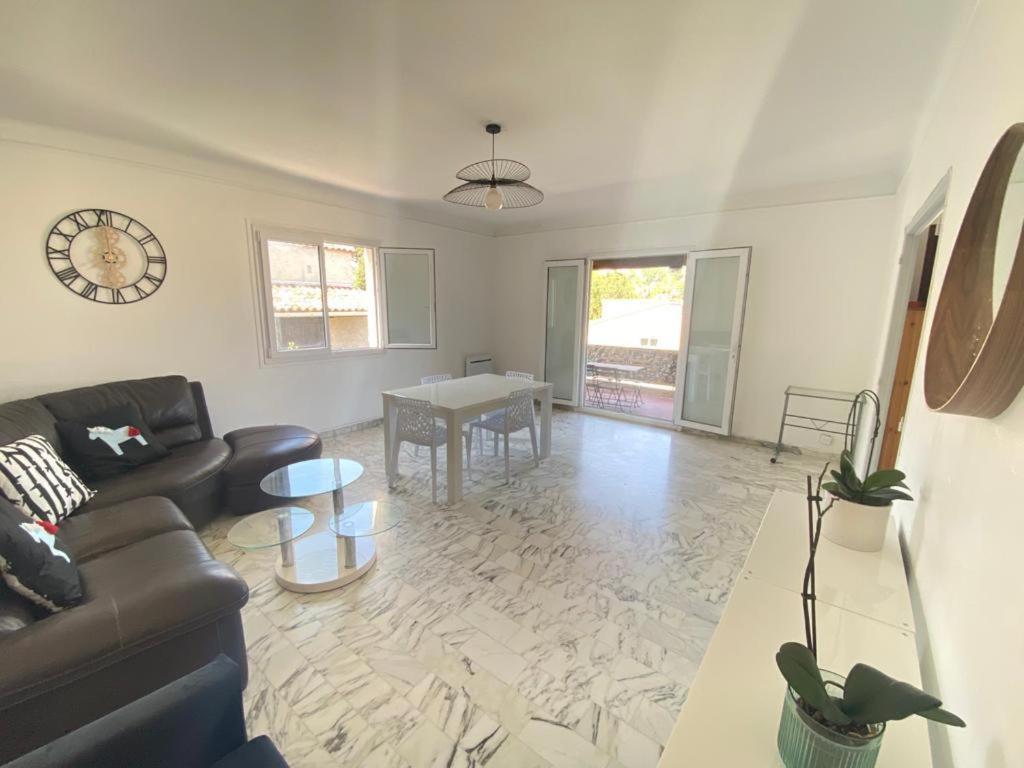 a living room with a couch and a table at Villa Emeraude in Cagnes-sur-Mer
