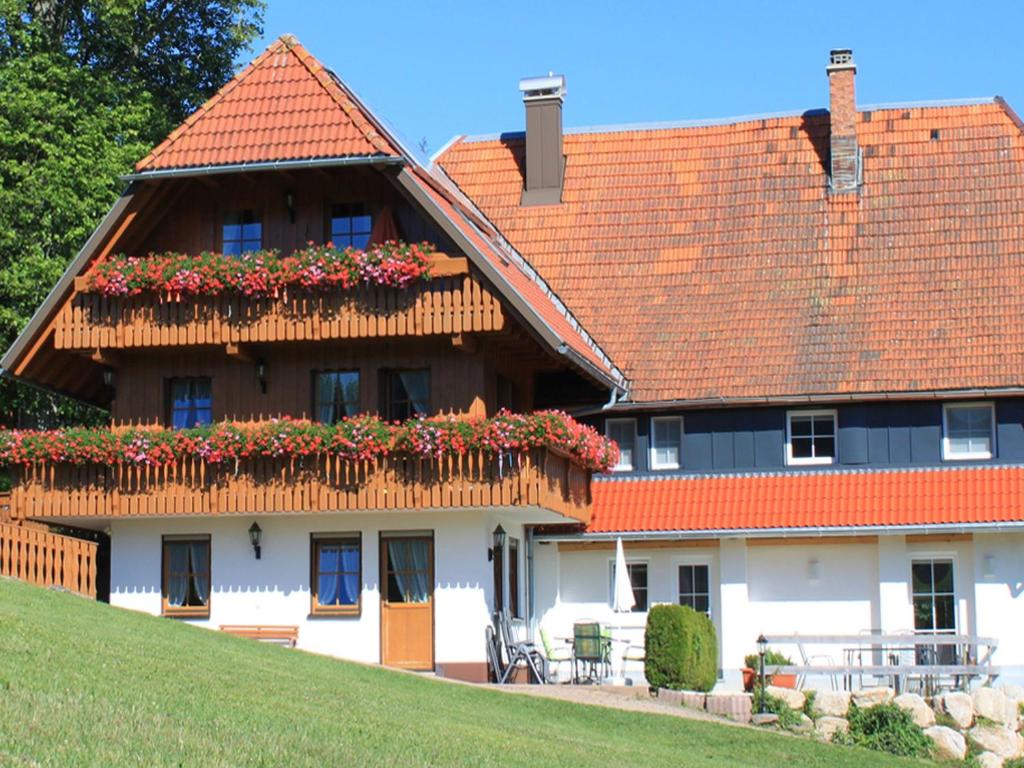 a house with a balcony with flowers on it at Glashof in Sankt Georgen im Schwarzwald