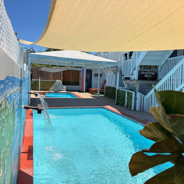 a swimming pool with an umbrella and a swimming poolvisor at Walk to Beach - Pool - Billar - Apto D in Guanica