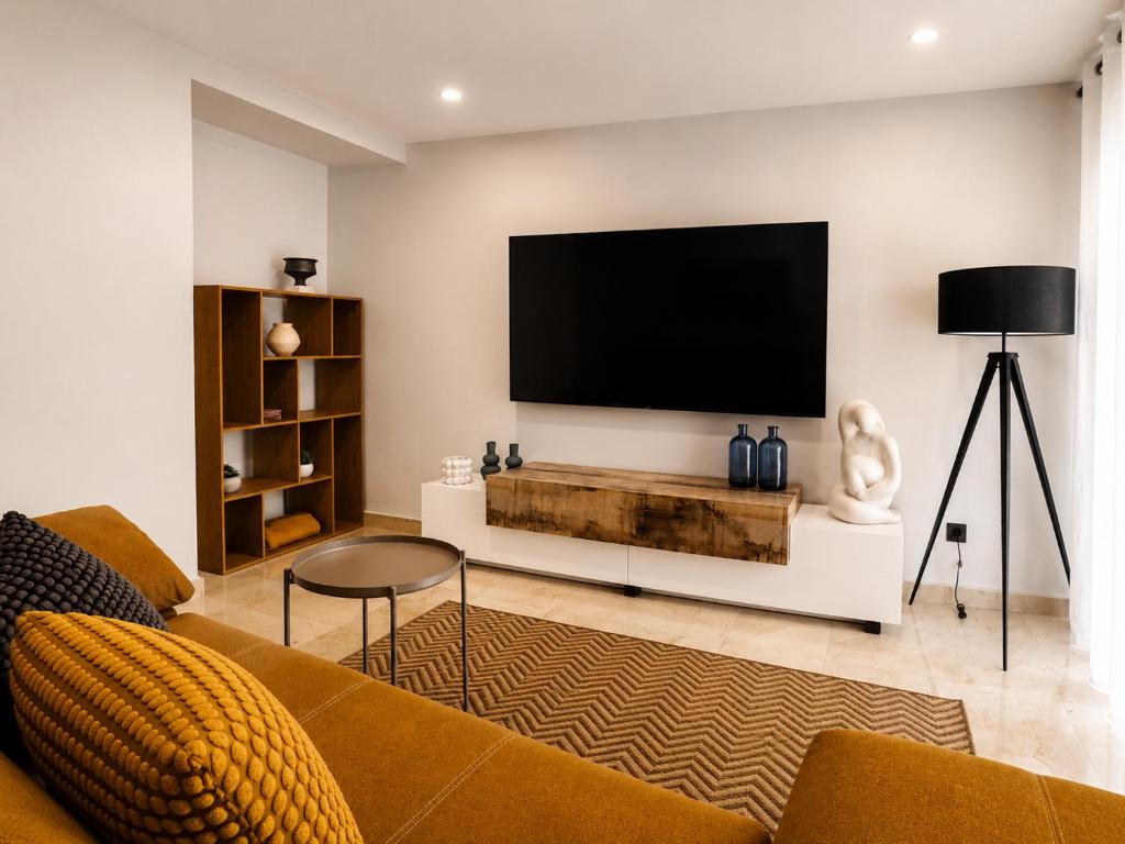 a living room with a flat screen tv on a wall at Aurah Home in Tudela