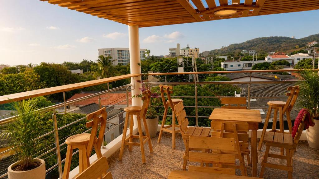 a balcony with chairs and tables and a view at Brisa y Lienzo - Hostal Boutique in Puerto Colombia