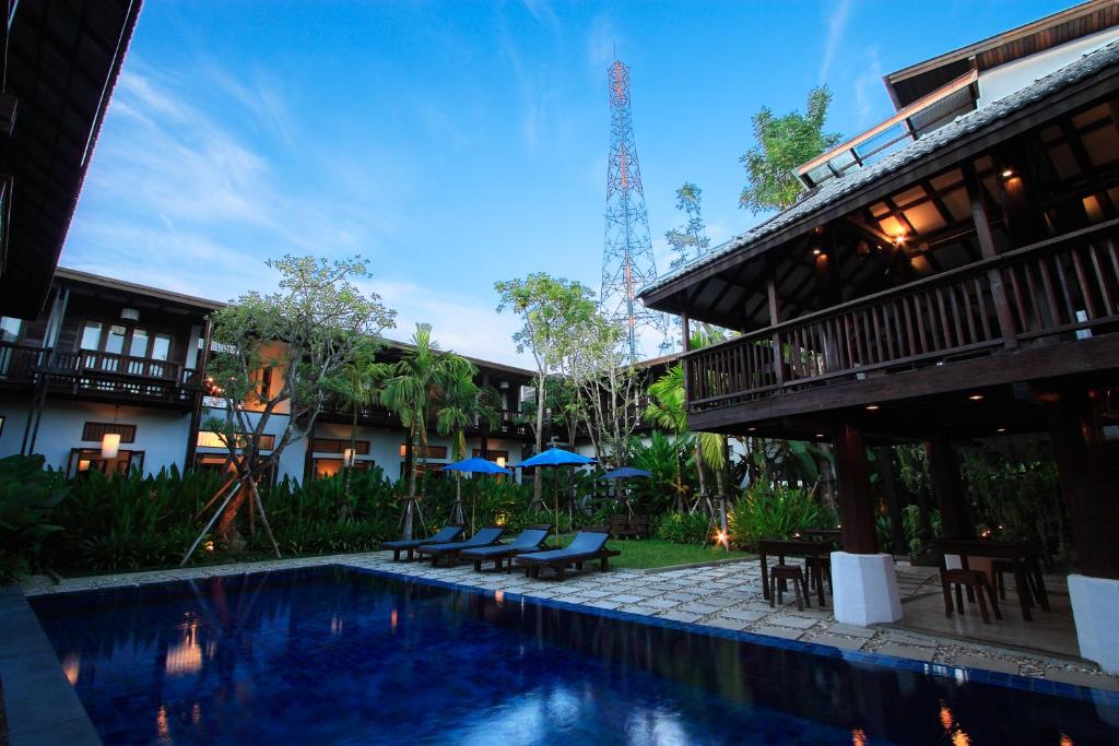 un complexe avec une piscine en face d'un bâtiment dans l'établissement Banthai Village, à Chiang Mai